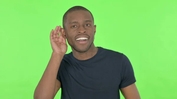 Hombre Africano Escuchando Secreto Sobre Fondo Verde —  Fotos de Stock