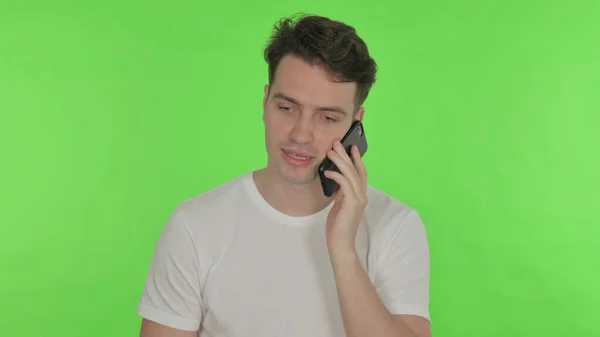 Випадковий Молодий Чоловік Говорить Телефону Зеленому Тлі — стокове фото