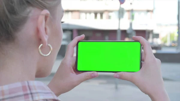 Close Up of Casual Woman Holding Horizontal Smartphone with Green Screen Outdoor