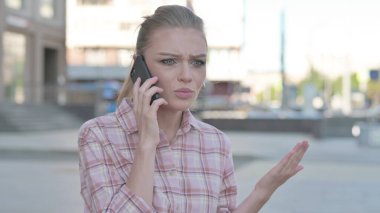 Angry Casual Woman Talking on Phone Outdoor