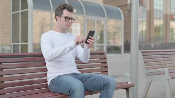 Casual Man Using Smartphone While Sitting Outdoor Bench — Foto de Stock