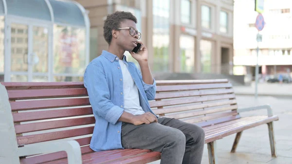 Африканский Человек Разговаривает Телефону Сидя Скамейке — стоковое фото
