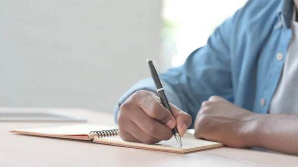 Close African Man Writing Notebook — стоковое фото