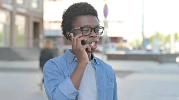 Angry African Man Talking on Phone Outdoor