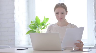 Young Woman Working on Laptop and Documents