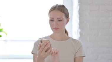 Young Woman using Smartphone for Browsing Internet