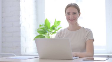 Shaking Head in Acceptance, Approval by Young Woman Working on Laptop