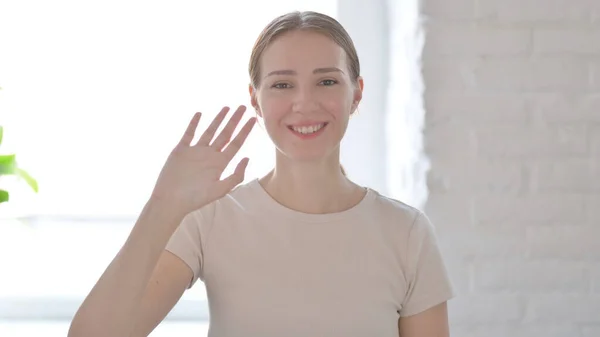 Young Woman Waving Hand to Say Hello
