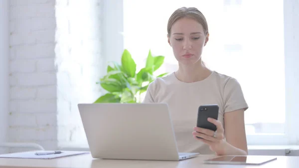 Mujer Joven Usando Smartphone Mientras Usa Laptop — Foto de Stock