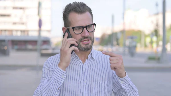 Angry Adult Man Talking on Phone Outdoor