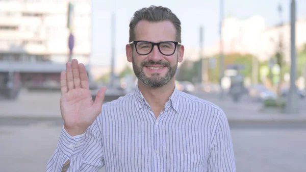 Welcoming Adult Man Waving Hand for Hello Outdoor