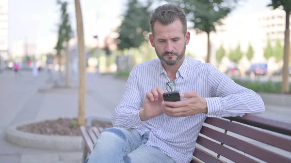Adult Man Using Smartphone While Relaxing Bench — Fotografia de Stock