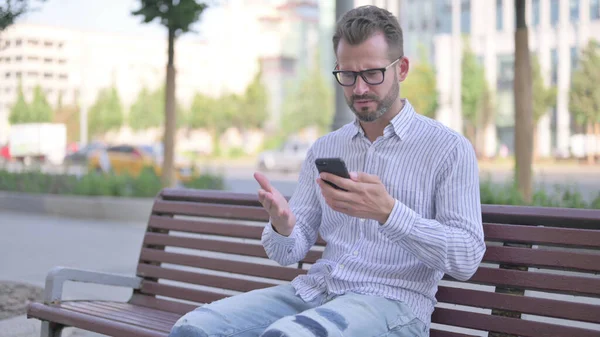 Adult Man Reacting Loss Smartphone While Sitting Outdoor Bench — Foto de Stock