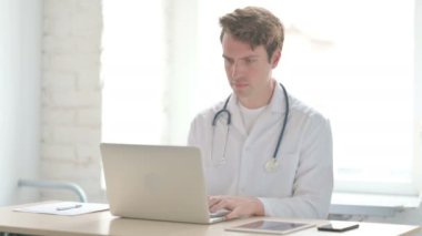 Erkek Doktor Klinikte otururken Kameraya Bakıyor