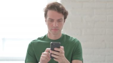 Akıllı telefondaki kayıplara tepki veren sıradan bir genç adam.