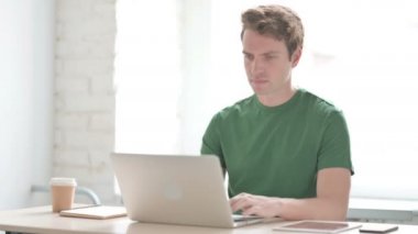 Dizüstü bilgisayar kullanırken Sırt Ağrısı Olan Sıradan Genç Adam 