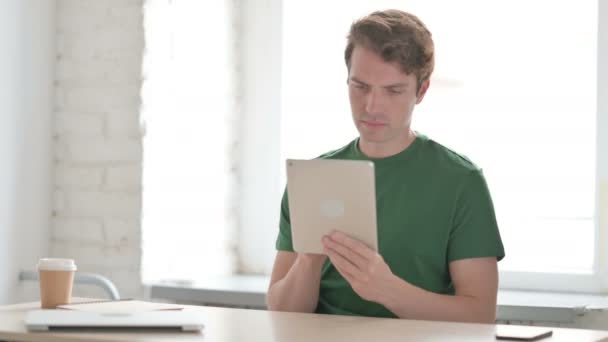 Casual Νεαρός Άνδρας Που Χρησιμοποιεί Ψηφιακή Ταμπλέτα Στην Εργασία — Αρχείο Βίντεο
