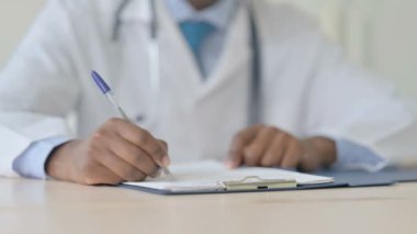 Tıbbi Belgeler üzerinde çalışan Afro-Amerikalı Doktor