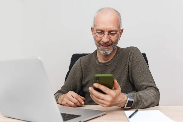 Spokojen Starší Muž Dívá Mobilní Telefon Usmívá Royalty Free Stock Obrázky