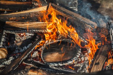Kamp ateşinde odun yakmak.