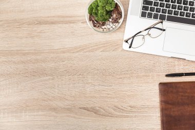 Laptop ve ofis malzemeleriyle ofis masasının en üst görüntüsü, yerleştirme için boş alan