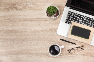 Bilgisayarın üst görüntüsü, kahve fincanı, ofis masasında akıllı telefon ve yerleştirme için boş alan