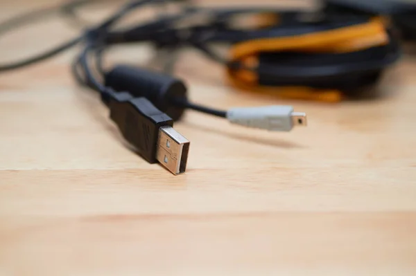 several charging cables lying on a table, including USB A  2.0 and USB C and AV cable