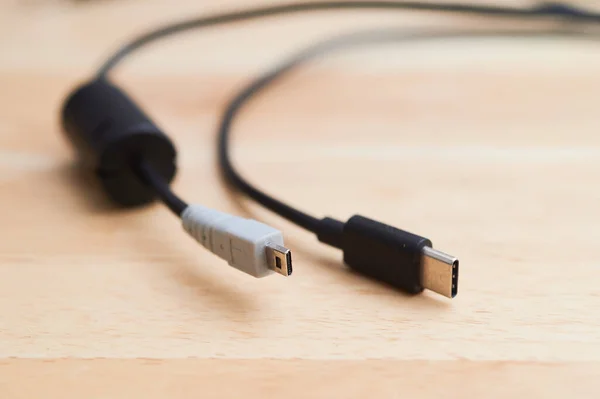 several charging cables lying on a table, including USB A  2.0 and USB C and AV cable