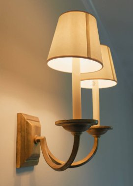 Klasik görünümlü çift lamba duvar armatürü, turuncu ve deniz mavisi aksanlı abajur gölgeli.