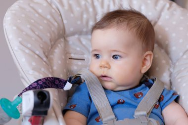 Yüksek sandalyedeki mutlu erkek bebek