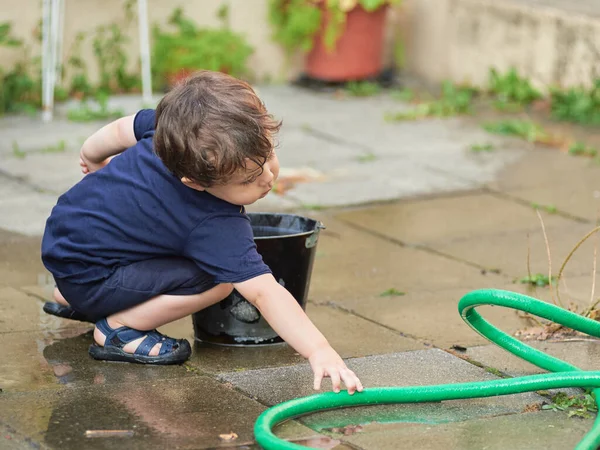 Young Boy Playing Watering Hose Buckets Backyard — Stock Photo, Image