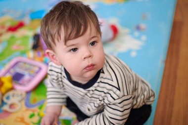 Küçük çocuk çocuk çocuk odasında oynuyor. 