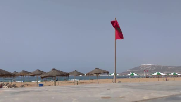 モロッコの旗がアガディールとビーチで手を振る私たちの男の背景 — ストック動画