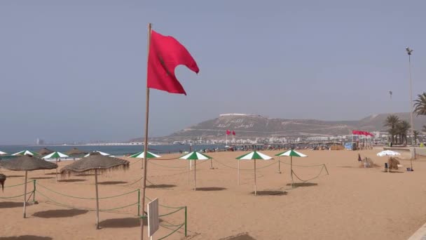 モロッコの旗がアガディールのビーチで手を振る — ストック動画