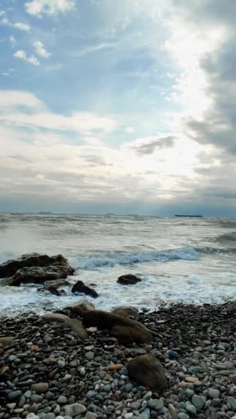 在一个美妙的日子里 海水冲撞着岩石的海滩 身后是一艘商船 — 图库视频影像