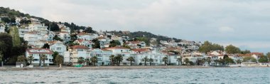 white and modern turkish houses near sea on princess islands, banner clipart