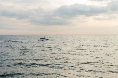 Günbatımında Bosporus 'ta dalgalı denizde seyreden modern beyaz gemi. 
