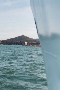 Ön planda bulanık feribot ile Bosporus 'taki deniz kıyısındaki iskelede Türk bayrağı