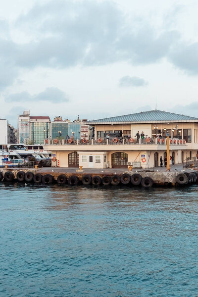 ISTANBUL, TURKEY - MAY 8, 2022: black life buoys around boats and pier near bosporus in istanbul 