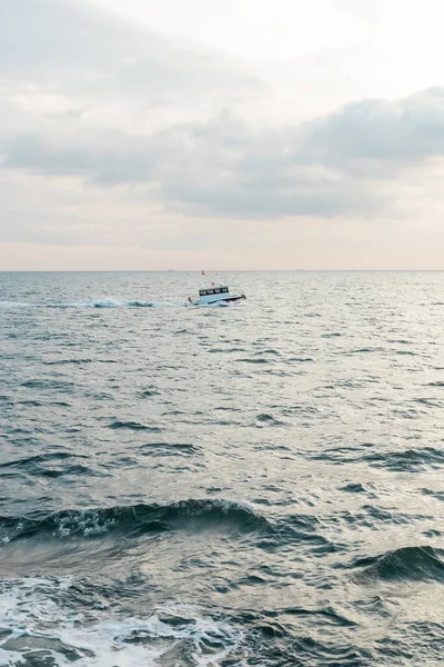 Современный белый корабль, плывущий в волнистом море по проливу Босфора во время заката — стоковое фото