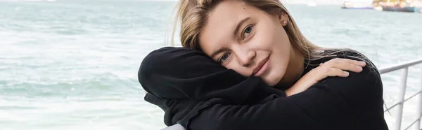 Mulher loira em camisola preta olhando para a câmera de barco de balsa cruzando bosporus, banner — Fotografia de Stock