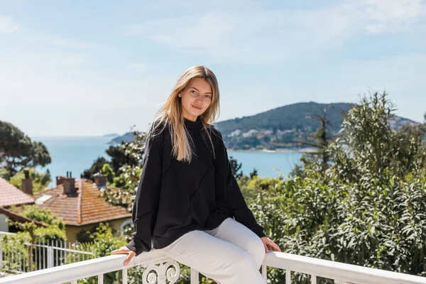Young and blonde woman posing near houses and sea on princess islands in turkey — Stock Photo