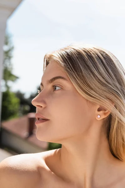 Portrait of young blonde woman with bare shoulder looking away — Stock Photo