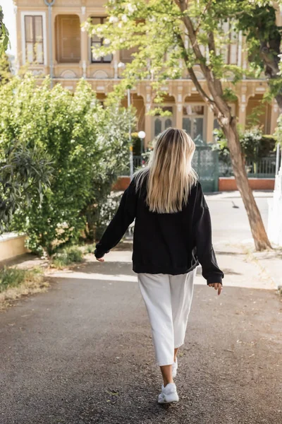 Rückansicht einer jungen blonden Frau in stylischem Outfit, die auf der Straße in der Türkei spaziert — Stockfoto