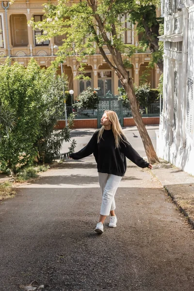 Сонячне світло обличчя щасливої блондинки в модному вбранні, що йде на вулиці в Туреччині — стокове фото