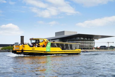 COPENHAGEN, DENMARK - CIRCA Temmuz 2022: Şehir su otobüsü her gün ulaşılan bir araçtır. Arka planda Kopenhag Opera Binası 'nı görebilirsiniz..