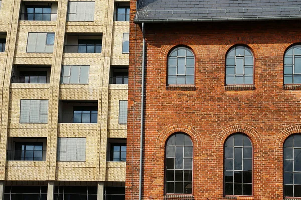 COPENHAGEN, DENMARK - CRCA HAZİRAN 2022: Eski ve yeni Danimarka mimarisi. Tarihi binanın yanında yeni inşa edilmiş bir apartman bloğu görülüyor.