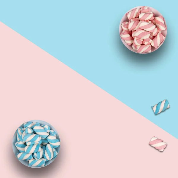 Mavi ve pembe arkaplanda renkli şekerleme ve kopyalama alanı olan iki tencere..