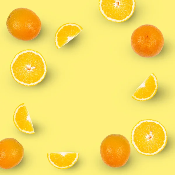 Oranges and slices of oranges isolated on yellow background, copy space.