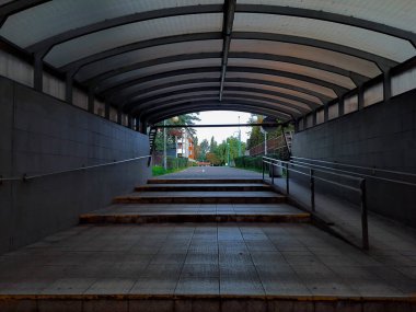 Boş yeraltı yaya geçidi. Tünelin sonunda ışık var. Kemerli çatılı bir altgeçit. Metrodan caddeye bak. Şehir altyapısı. Terk edilmiş basamaklar yukarı çıkıyor..
